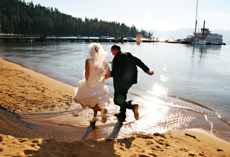 Couple skipping on beach at lake tahoe