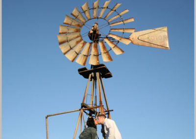 Engagement portrait by vintage windmill in Birds Landing, CA