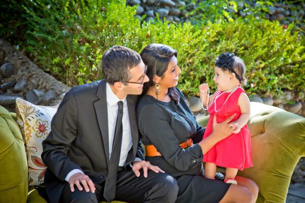 Dressy family on couch outside with toddler daughter