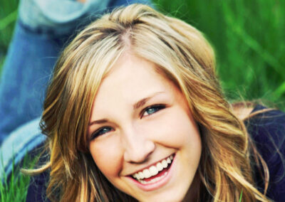 Senior girl laying in grass laughing