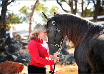 A woman touching foreheads with her horse