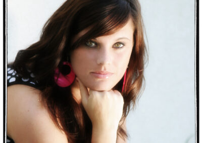 Senior girl posing for a head shot with her fist below her chin