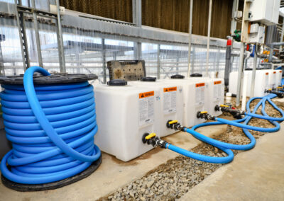 Blue hosing and tanks at industrial greenhouse for commercial use