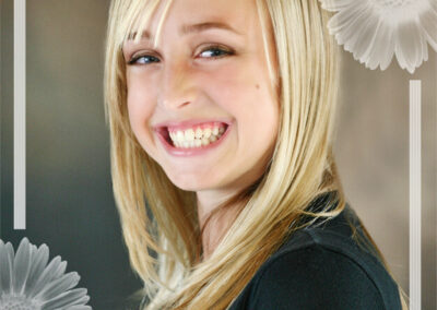 Senior girl headshot on background posed smiling with her body turned and head facing camera