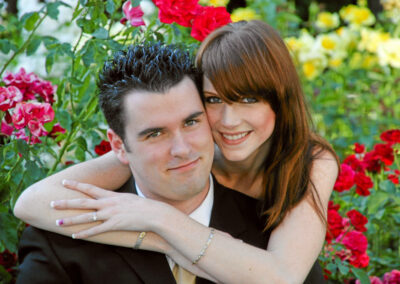 Woman hugging man from behind at Engagement Session at the State Capitol Park World Peace Rose Garden at Capitol Park, Sacramento, CA