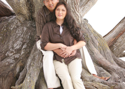 Couple leaning against tree on the beach at Carmel beach, CA