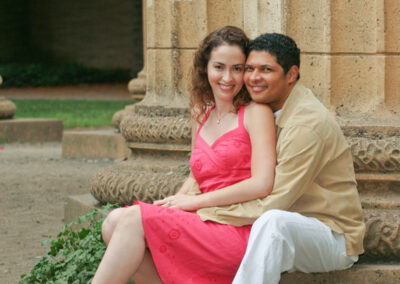 Couple embracing each other while sitting on a column at the Palace of Fine Arts in San Francisco, CA