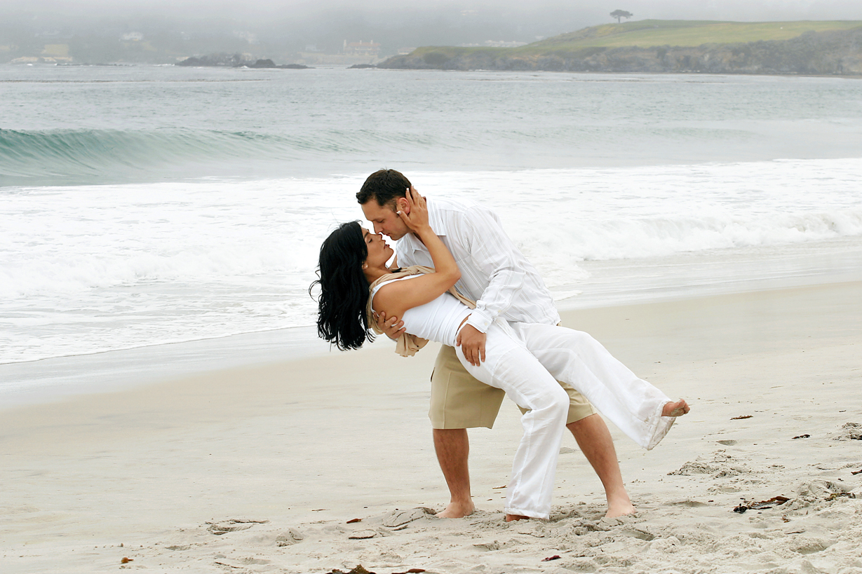 Couple dipping on the beach in Carmel, CA