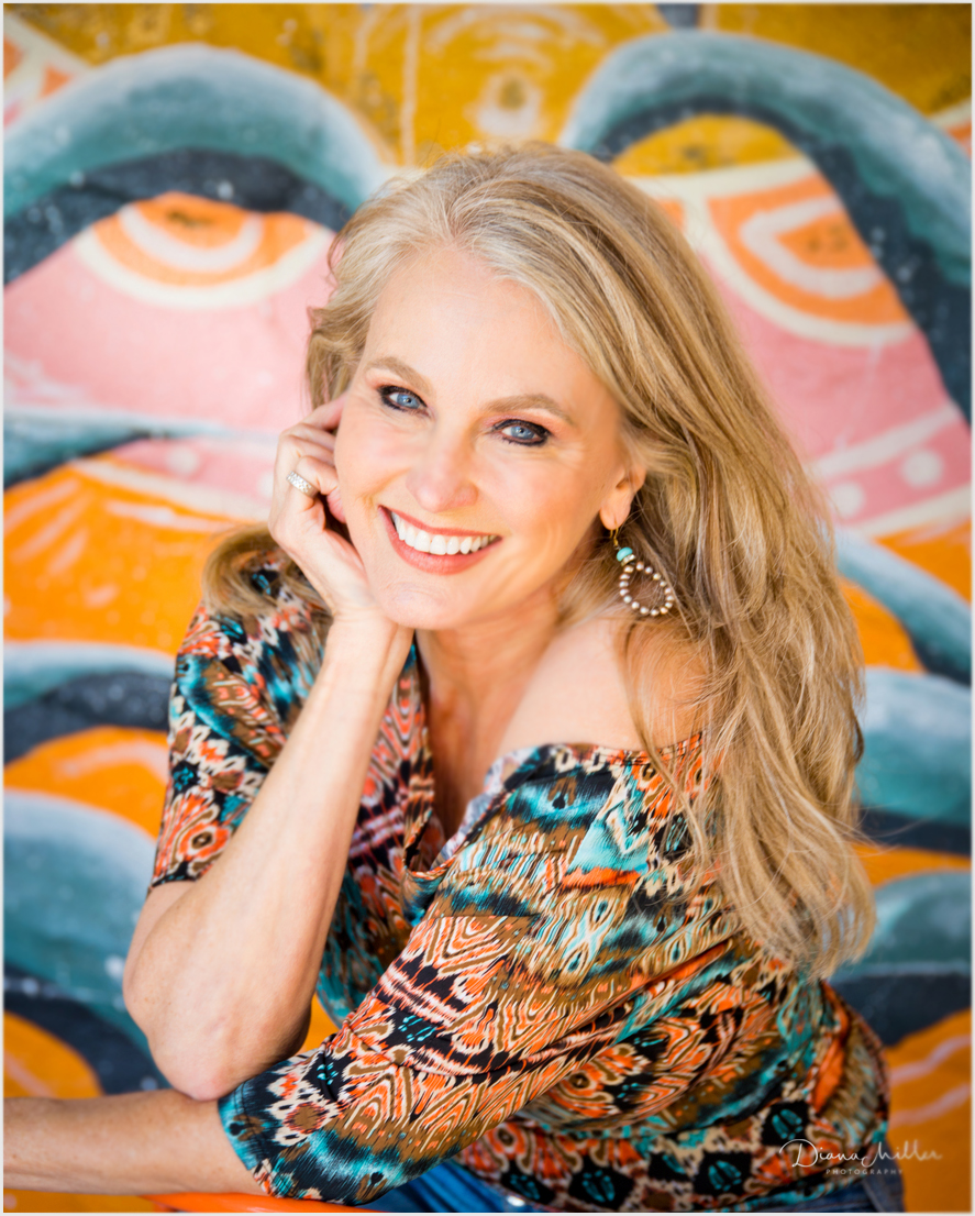 Headshot of older woman with mural behind her